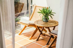 Photo de terrasse de vacances avec une table et une chaise inclinée en bois qui invite à la détente et au repos